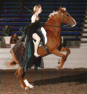 Erica Franz, in costume, on a rearing horse